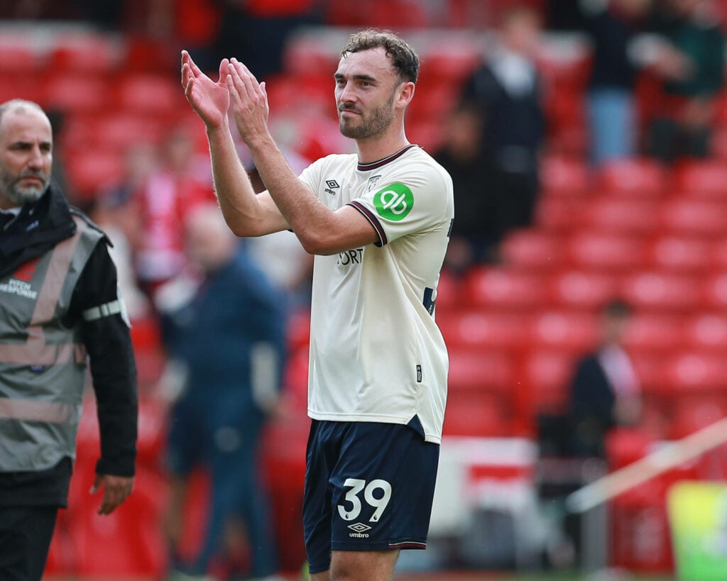 Andy Irving clapping while wearing the West Ham away shirt